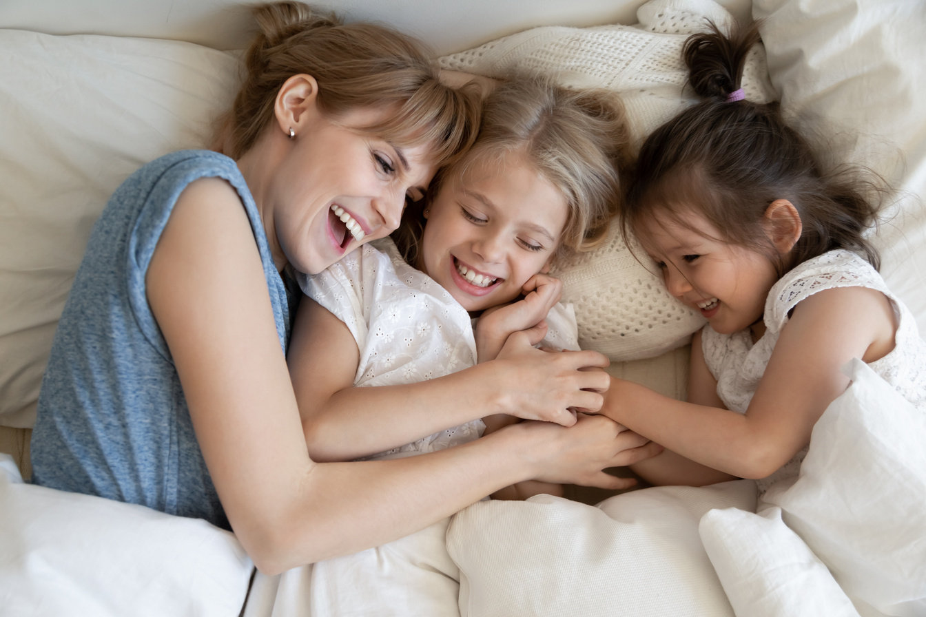 Mum and kids cuddling in bed